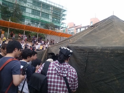 8일 오후 서울 양천구 신원초등학교에서 열린 T24페스티벌에서 이광낙씨가 2시간만에 완성한 24인용 군용텐트를 관람객들이 확인하고 있다.