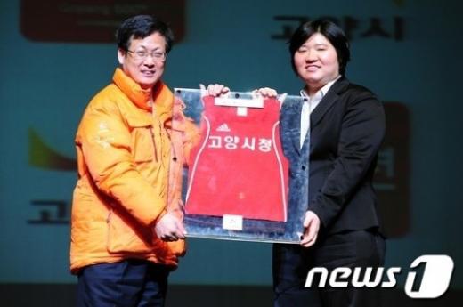 장미란이 29일 오후 경기도 고양 어울림극장에서 열린 은퇴식에서 최성 고양시장에게 유니폼을 반납하고 있다. 이 유니폼은 고양 장미란체육관에 기증할 예정이다. ⓒ뉴스1