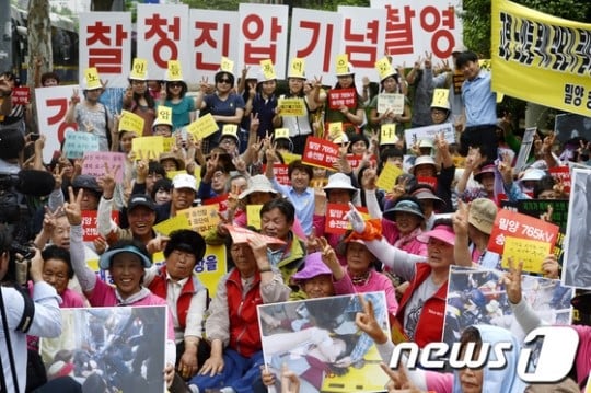 밀양765kV송전탑반대대책위원회 등 밀양 주민들이 16일 오전 서울 서대문구 미근동 경찰청 앞에서 '국민 대집행 경찰청 철거 영장 발부' 기자회견 중 여경들의 기념촬영을 풍자하며 브이자를 그리고 있다. /사진=News1