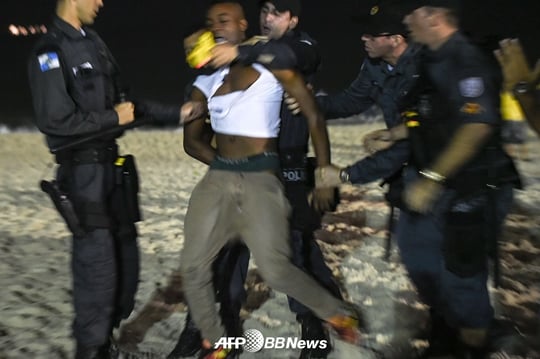 브라질 경찰이 리우데자네이루의 한 해변에서 난동을 부리고 있는 팬을 체포하고 있다. /AFPBBNews=뉴스1