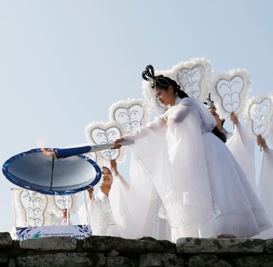 지난 8월 12일 강화도 마니산 참성단에서 칠선녀가 성화봉에 불을 붙이고 있다. /사진=인천AG 조직위 제공