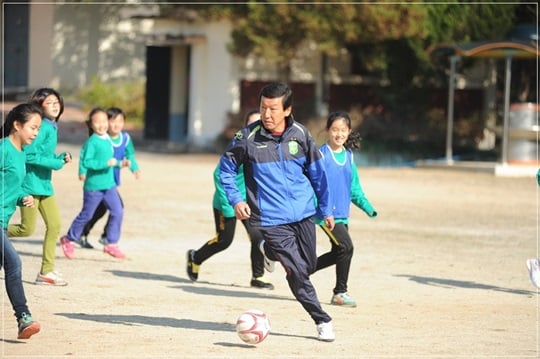 지난해 흥왕초등학교에서 열린 축구클리닉에 참가한 최강희 감독(가운데). /사진=전북 제공