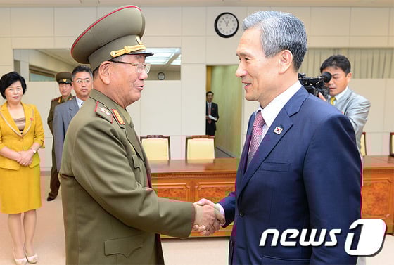 김관진 국가안보실장이 25일 새벽 판문점 평화의 집에서 33시간만에 남북 고위급 2차 회담을 마친 후 황병서 북한 군 총정치국장과 악수하고 있다./사진= 통일부 제공