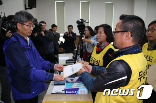 홍준표경남지사 주민소환운동본부 전진숙 대표(오른쪽 두번째)가 오전 경상남도선거관리원회에 6층 강당에서 36만6964명의 주민소환청구인 서명부를 도 선관위 관계자에게 제출하고 있다./사진=뉴스1
