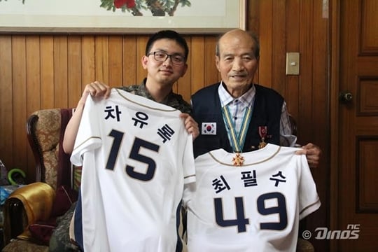 차유록 일병(왼쪽)이 입대연도인 2015년도의 뒤 번호인 '15'를 새긴 유니폼을, 최필수(오른쪽) 님이 입대연도인 1949의 뒤 번호인 '49'를 새긴 유니폼을 들고 있다. /사진=NC 다이노스 제공