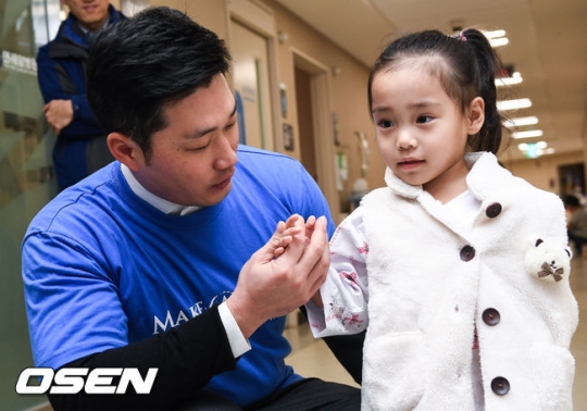 12월 21일 서울 신촌 세브란스 병원 소아암병동에서 오승환이 소아암 환아의 손을 만지며 인사를 하고 있다.