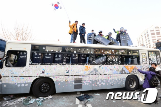 10일 오후 서울 종로구 안국역 네거리에서 탄핵반대집회 시위대가 경찰버스에 올라 태극기를 흔들고 있다./사진=뉴스1