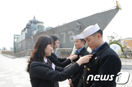 제7주기 천안함 용사 추모식에 참석한 대동세무고 최민 학생과 덕원여고 이수윤 학생이 장병들에게 천안함 기억 배지를 달아주고 있다./사진=뉴스1
