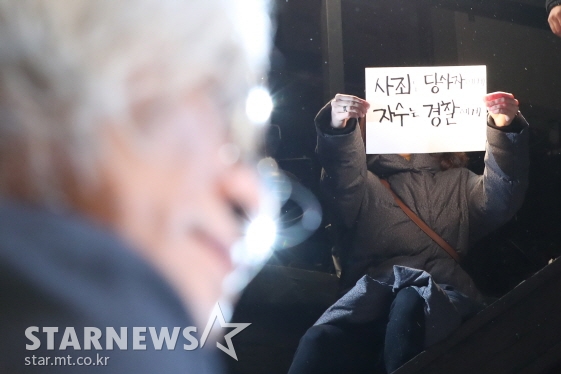 이윤택 연출가가 성폭력 관련 기자회견을 하는 가운데 피켓 시위를 하는 모습/사진=이기범 기자