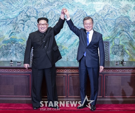 문재인 대통령과 김정은 국무위위원장이 27일 오후 경기도 파주 판문점에서 '판문점 선언문'에 사인, 교환한 뒤 서로 손을 잡고 활짝 웃고 있다./사진=한국공동사진기자단