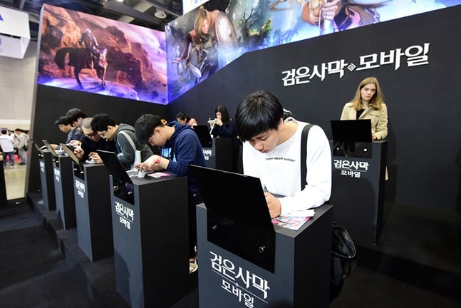 모바일 게임 '검은사막 모바일'을 즐기고 있는 참관객들.