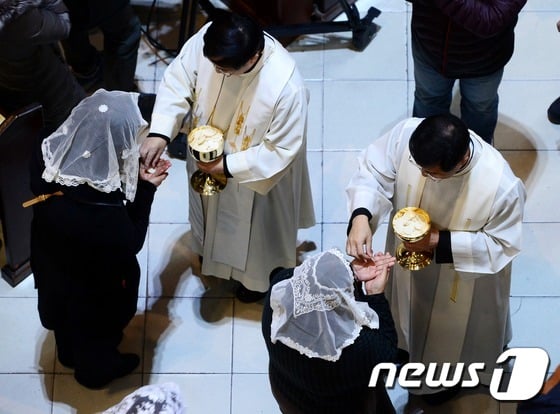 성당 미사에서 천주교 신자들이 성체성사를 하고 있다./사진=뉴스1