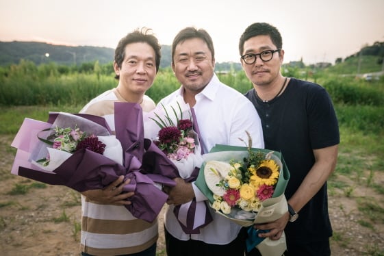 박지환과 마동석, 김민호 감독이 '성난황소' 크랭크업을 축하하는 꽃다발을 들고 포즈를 취하고 있다/사진제공=쇼박스
