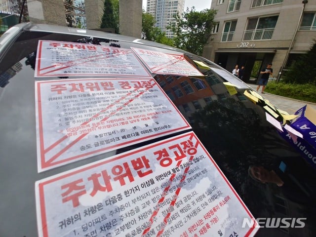 지난 27일 인천 연수구 송도동 아파트 정문 주차장 진출입로를 승용차로 막은 50대 여성 A씨가 차량 조수석에 본드칠한 주차위반 스티커를 붙여 화가 나서 그랬다고 밝혔다. / 사진=뉴시스