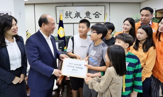 한화갤러리아 사회공헌활동 ‘희망트레이너’ 참여 어린이들이 24일 아동권리를 수호하기 위한 지역 사회의 문제점 개선을 적은 제안서를 영등포구의회 윤준용 의장에게 전달하고 있다/사진제공=갤러리아