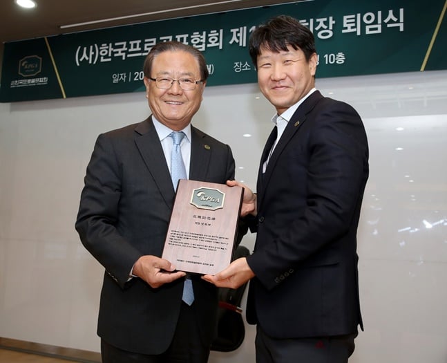 양휘부(왼쪽) 회장이 KPGA 김성철 운영팀장으로부터 KPGA 임직원들이 준비한 재직기념패를 전달받고 있다. /사진=KPGA