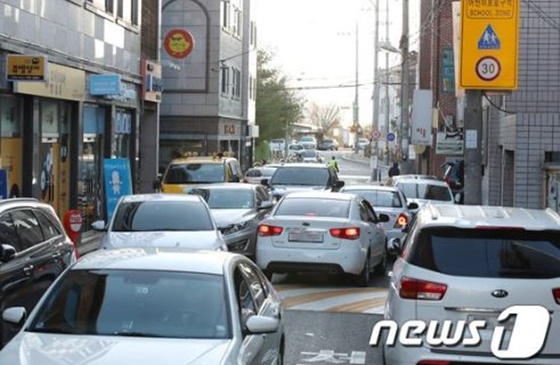/사진=뉴스1 자료화면(지난해 11월 대구 수성구 매호동 한 초등학교 앞 도로를 지나는 차량이 불법주·정차된 차량으로 인해 복잡하게 뒤엉켜 어린이 안전을 위협하고 있다)