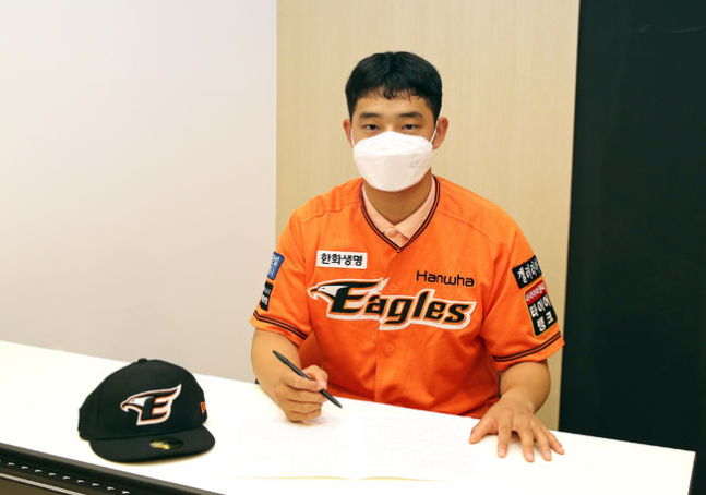 한화 1차지명 문동주가 계약서에 사인하고 있는 모습./사진=한화 이글스