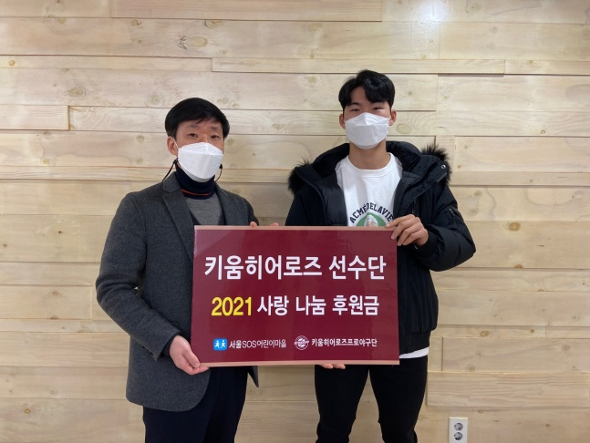 키움 주장 김혜성(오른쪽)이 서울SOS어린이마을에 후원금을 전달하는 사진을 찍고 있다./사진=키움 히어로즈