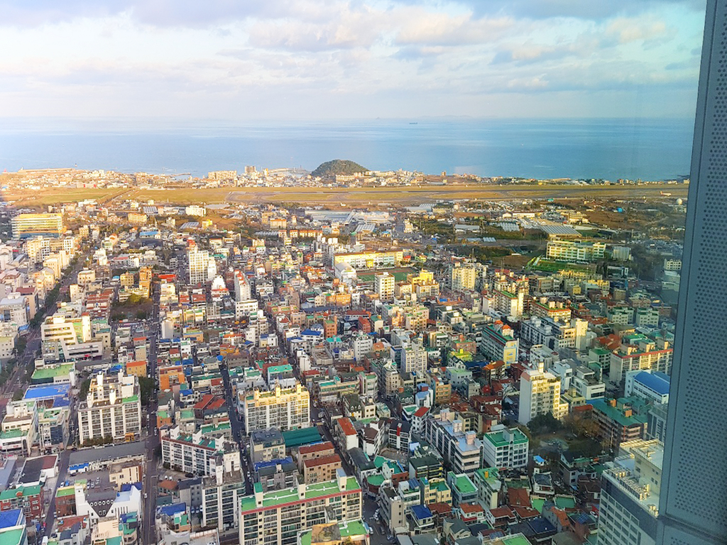 37층 객실에서 내려다본 제주시내와 공항활주로. 2.7m의 통유리 벽면은 탁트인 전경을 선사한다.
