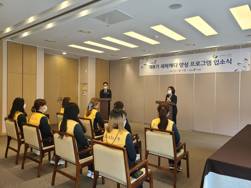 골프코스 토탈 서비스 기업 골프존카운티가 북한이탈주민의 안정적인 사회 정착에 기여한 공로를 인정받아 통일부 장관 표창을 수상했다. 골프존카운티 안성H에서 열린 제8기 새싹 캐디 양성 프로그램 입소식에 참석한 캐디 교육생들이 개회사를 듣고 있다. /사진제공=골프존카운티