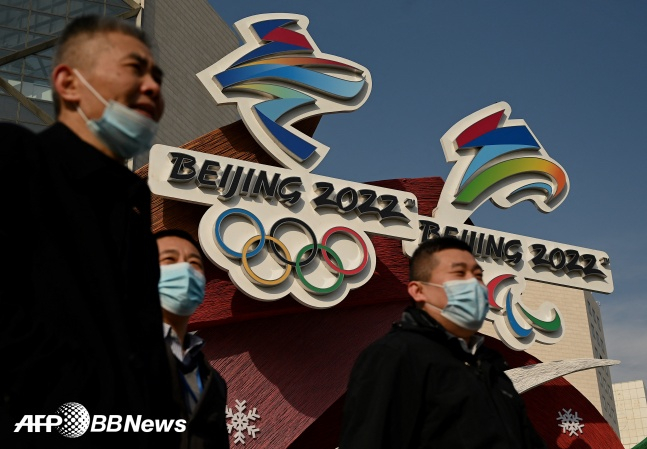 2022 베이징 올림픽 로고 앞을 사람들이 지나고 있다./AFPBBNews=뉴스1