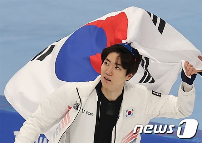 차민규가 12일 중국 베이징 국립 스피드스케이팅 경기장에서 열린 2022 베이징 동계올림픽 스피드스케이팅 남자 500m 경기를 마친 뒤 태극기를 들고 빙판 위를 달리고 있다./사진=뉴스1