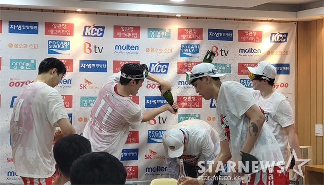 프로농구 서울 SK의 통합 우승이 확정된 10일 서울잠실학생체육관 인터뷰실을 급습해 전희철(가운데) 감독에게 샴페인 세리머니를 펼치고 있는 선수들. /사진=김명석 기자