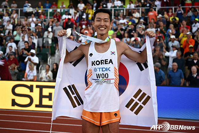 우상혁이 19일 미국 오리건주 유진 헤이워드 필드에서 열린 세계육상선수권대회 남자 높이뛰기에서 은메달을 차지한 뒤 태극기를 두른 채 기뻐하고 있다. /AFPBBNews=뉴스1
