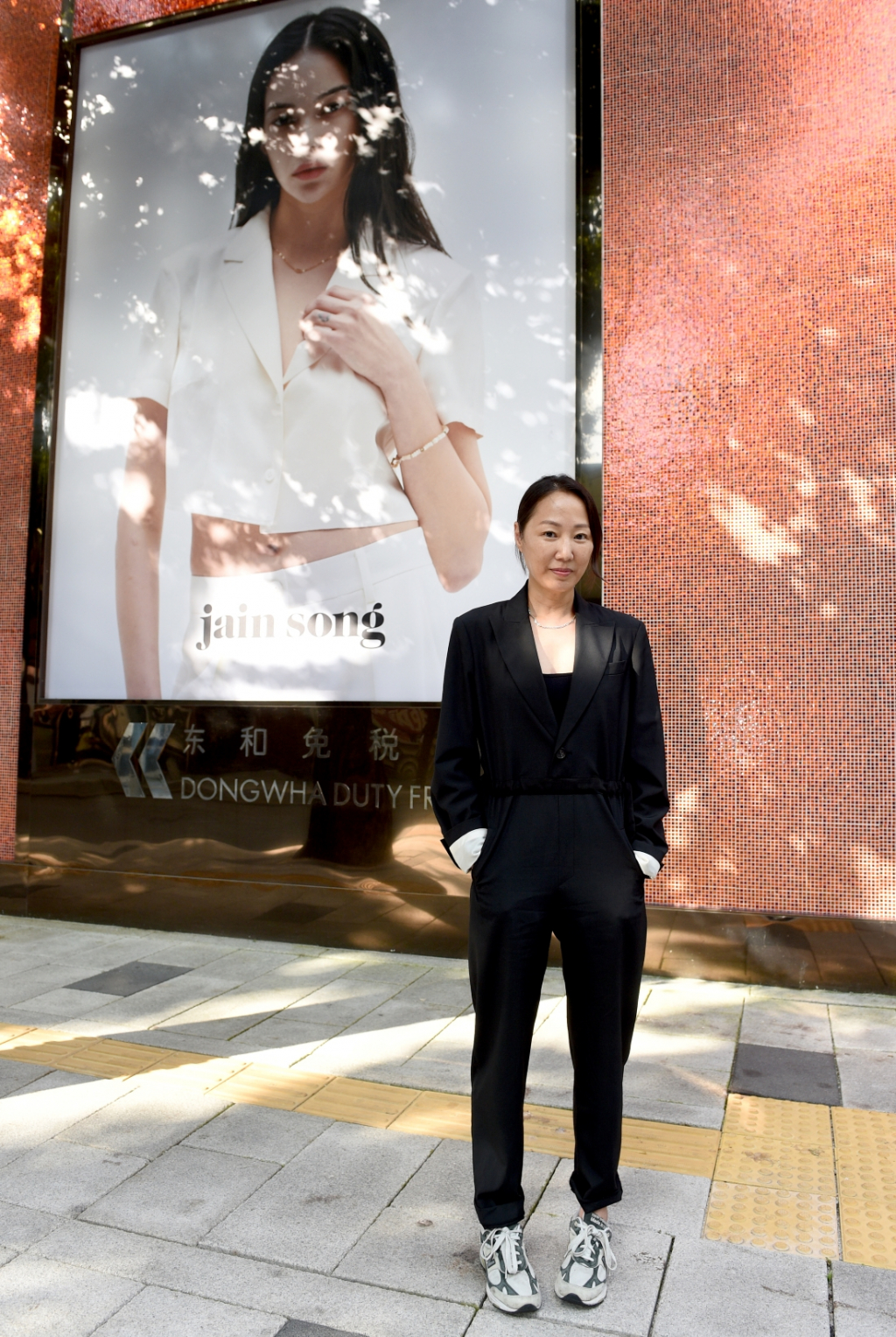송자인 디자이너가 광화문빌딩에 설치된 외벽광고 앞에서 기념촬영을 하고 있다. /사진제공=롯데관광개발