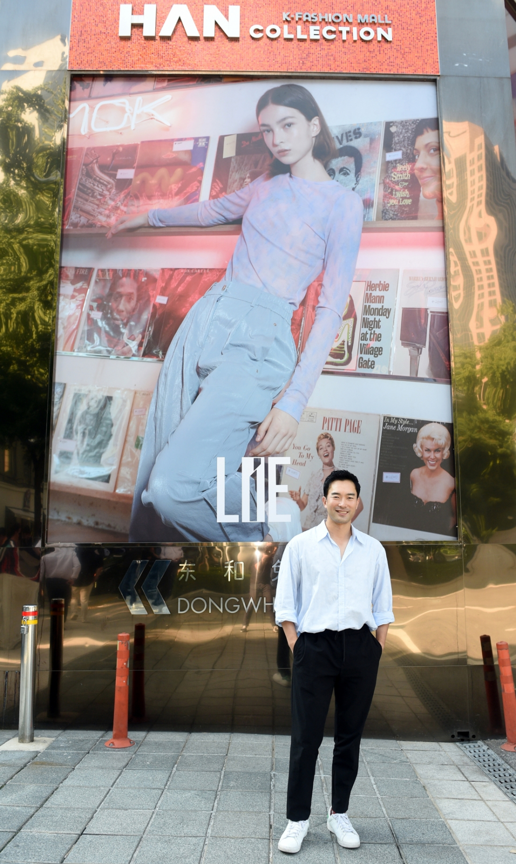 이청청 디자이너가 광화문빌딩에 설치된 외벽광고 앞에서 기념촬영을 하고 있다. /사진제공=롯데관광개발