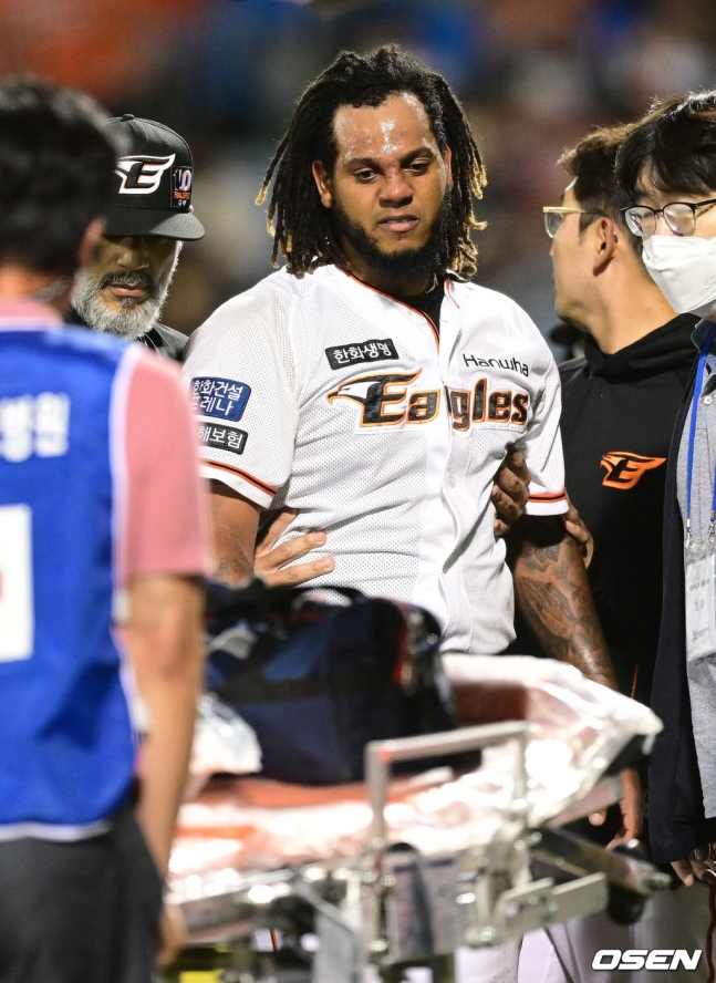 한화 페냐가 롯데 안치홍의 안타 타구에 코를 맞은 뒤 부축을 받고 일어서고 있다.