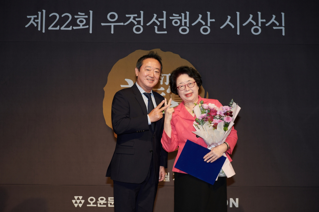 제22회 우정선행상 시상식에서 대상을 수상한 최경숙씨(오른쪽)와 이웅열 이사장(왼쪽)이 기념촬영을 하고 있다