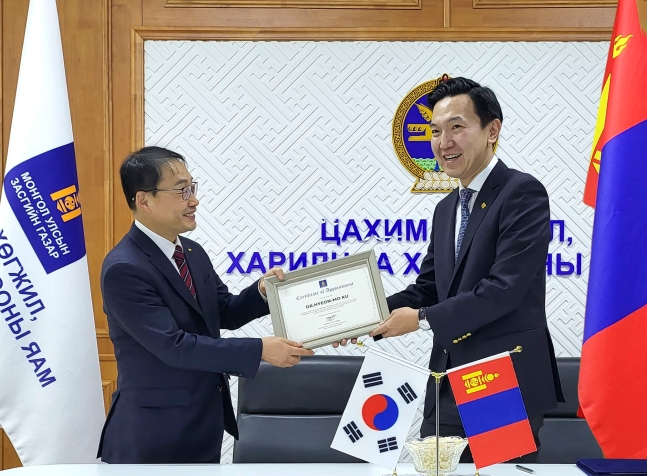 구현모(왼쪽) KT 대표(왼쪽)가 몽골 디지털개발부 오츠랄 니암오소르 장관으로부터 '몽골 최고기술경영자(CTO)' 위촉장을 전달 받고 있는 모습.