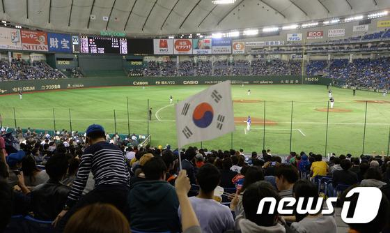 지난 2015년 11월 21일 일본 도쿄돔에서 열린 2015 세계야구소프트볼연맹(WBSC) 프리미어12 결승전 대한민국과 미국의 경기에서 한 관중이 태극기를 흔들며 응원하고 있다. /사진=뉴스1
