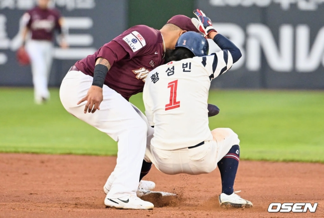 롯데 황성빈(오른쪽)이 28일 사직 키움전에서 1회 말 2루 도루 시도 과정에서 발목이 꺾이고 있다.