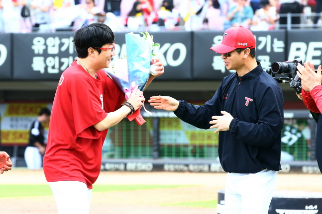 양현종(왼쪽)이 김종국 감독에게 축하 꽃다발을 받고 있다. /사진=KIA 타이거즈