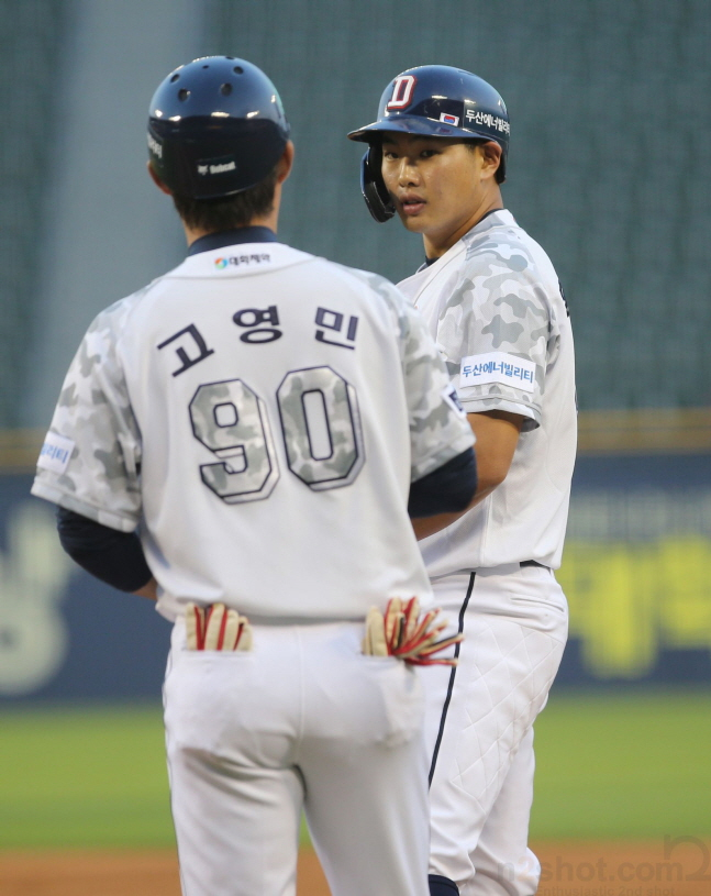 홍성호(오른쪽)가 첫 타석 안타 후 고영민 코치와 이야기를 나누고 있다. /사진=두산 베어스