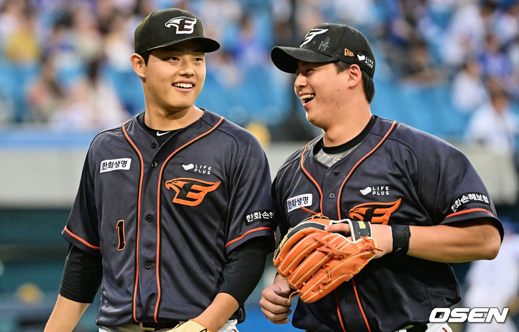 문동주(왼쪽)가 이닝을 마치고 노시환과 밝게 웃으며 더그아웃으로 향하고 있다. /사진=OSEN