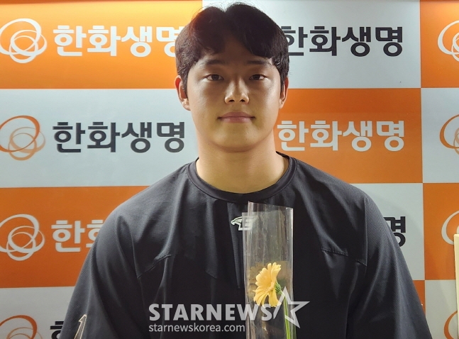 경기 후 어린 팬으로부터 받은 꽃을 들고 인터뷰를 하고 있는 문동주. /사진=안호근 기자
