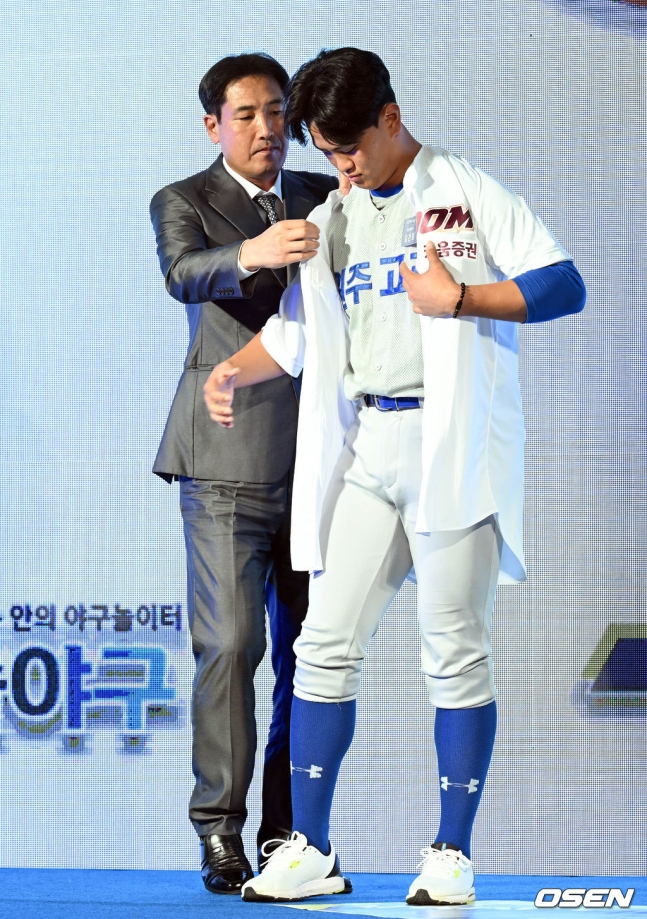 고형욱 단장이 지난해 열린 2023 KBO신인드래프트 1라운드로 키움이 지명한 김건희에게 유니폼을 입혀주고 있다.