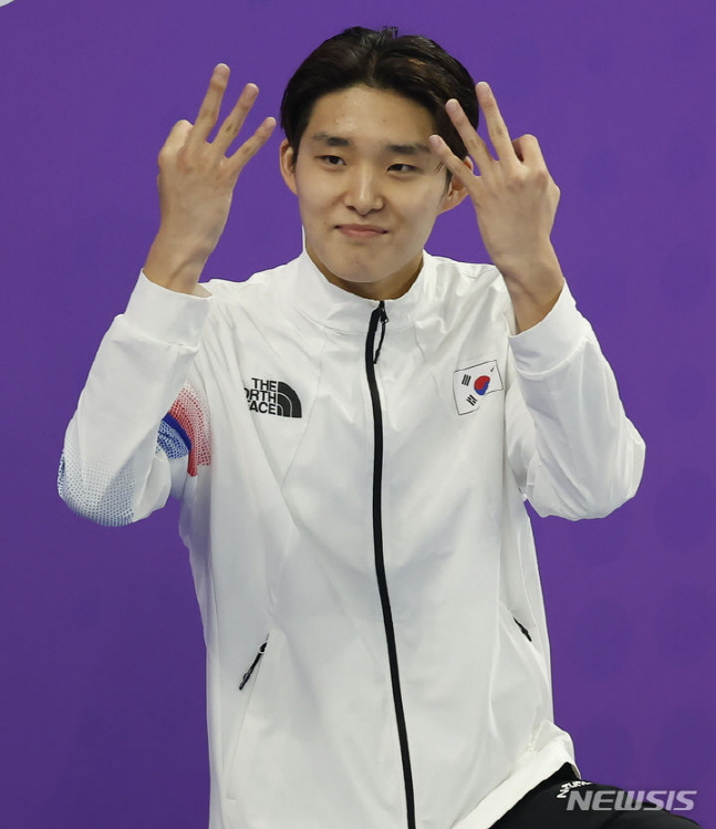 29일 자유형 400m에서 금메달을 차지한 김우민이 손가락으로 3관왕을 의미하는 표시를 하고 있다. /사진=뉴시스