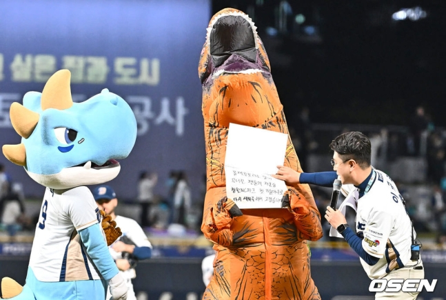 NC 팬 '공룡좌'가 19일 창원NC파크에서 열린 2023 KBO 와일드카드 결정전 1차전에서 시구 행사에 앞서 메시지를 들고 있다.