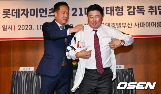 이강훈 롯데 구단 대표이사(왼쪽)가 24일 열린 롯데 제21대 감독 취임식에서 김태형 신임 감독에게 유니폼을 입히고 있다.