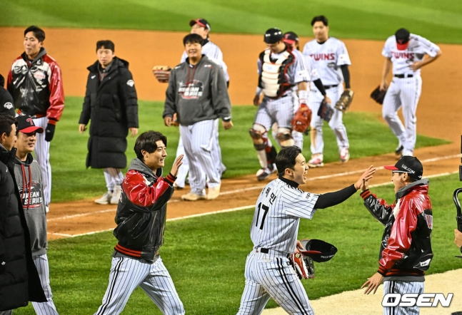 염경엽(오른쪽 아래) LG 감독이 한국시리즈 2차전 승리 후 선수들과 하이파이브를 나누고 있다.