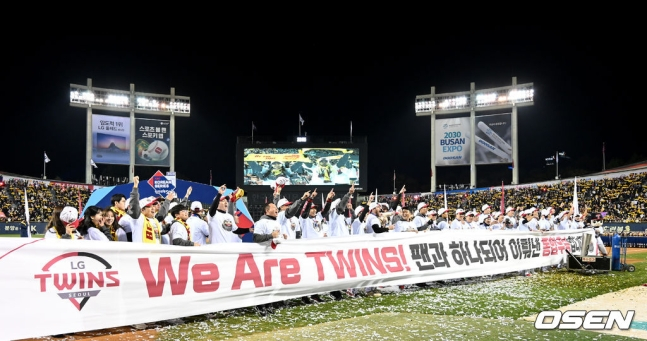 LG 선수단이 13일 서울 잠실야구장에서 열린 2023 KBO 한국시리즈 5차전에서 우승을 확정한 후 현수막을 들고 팬들에게 인사하고 있다.