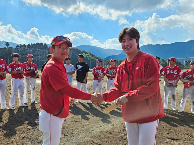 SSG 손시헌 퓨처스 감독(왼쪽)과 캠프 투수 MVP 이건욱이 악수를 나누고 있다. /사진=SSG 랜더스