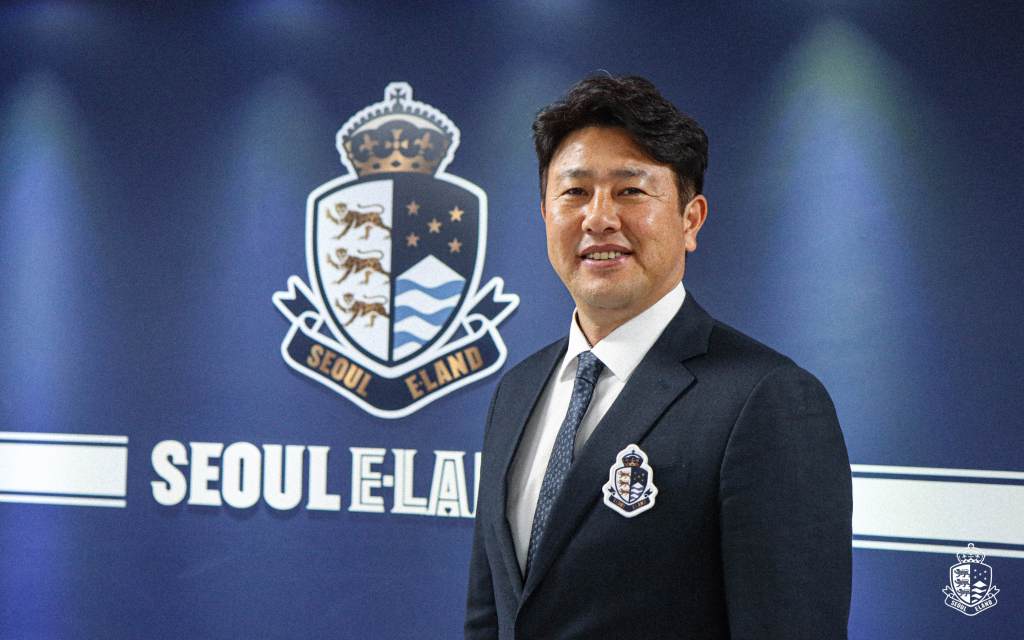 김도균 신임 감독이 서울 이랜드 로고 앞에서 미소 짓고 있다./사진제공=서울 이랜드