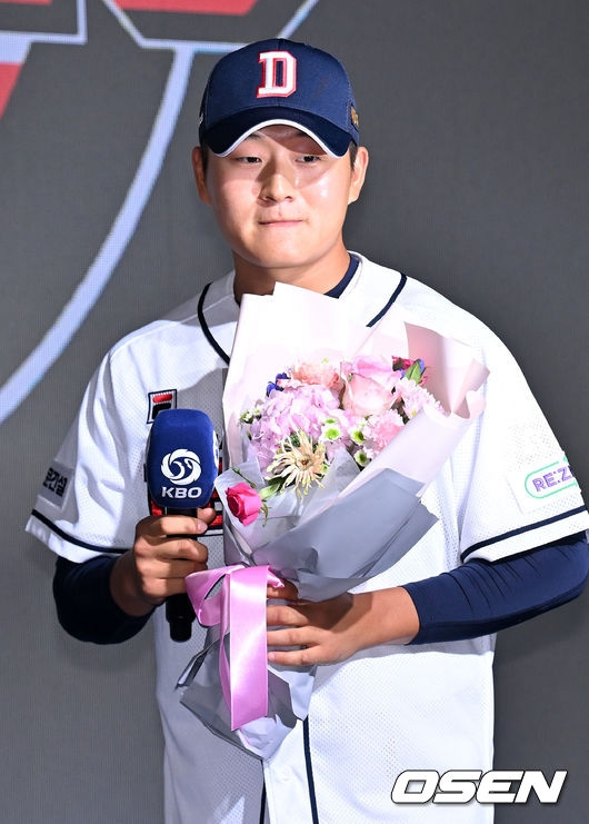 김택연이 두산 유니폼을 입고 사진 촬영에 임하고 있다.