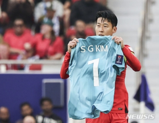 손흥민이 20일(한국시간) 요르단전에서 페널티킥 선제골을 넣은 뒤 부상으로 낙마한 김승규의 유니폼을 들어보이고 있다. /사진=뉴시스